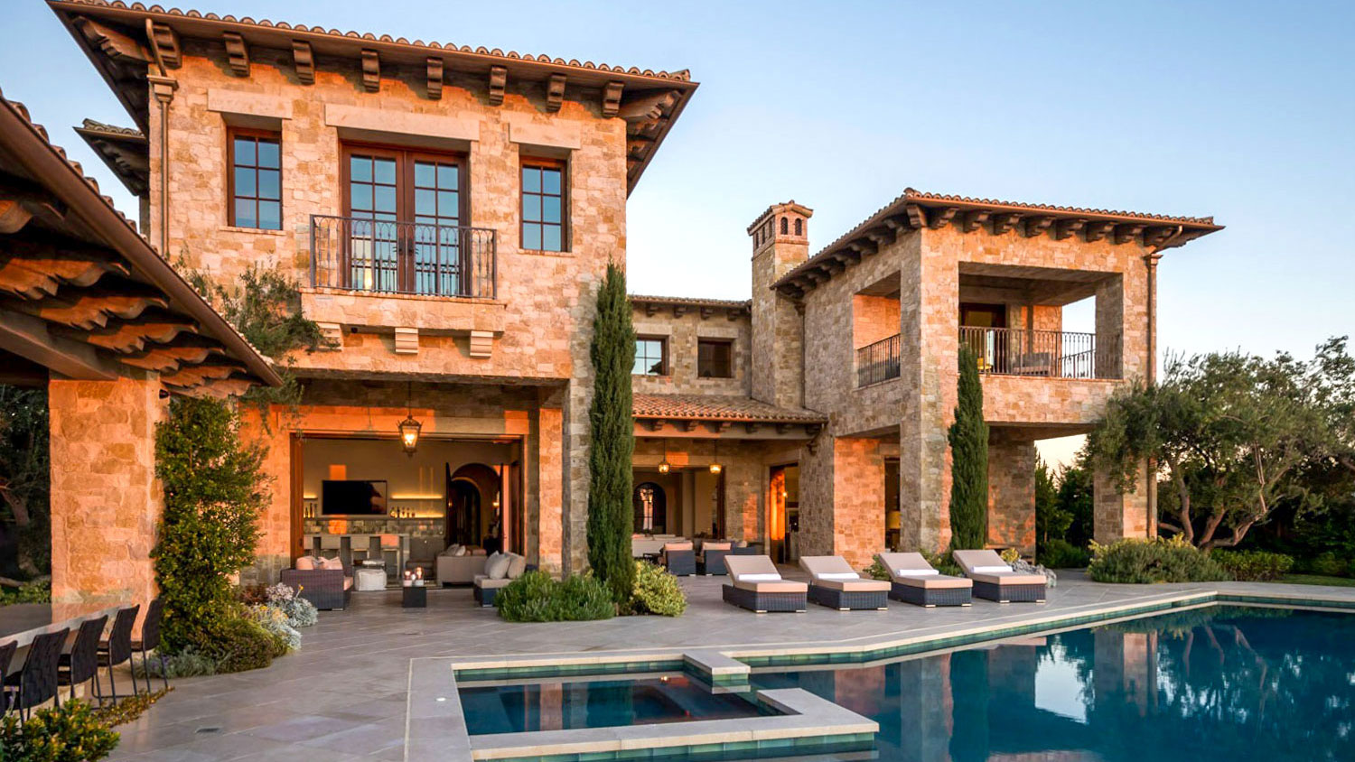 modern home pool deck with sunset reflecting off the Tuscan Blend Rubble thin veneer exterior walls