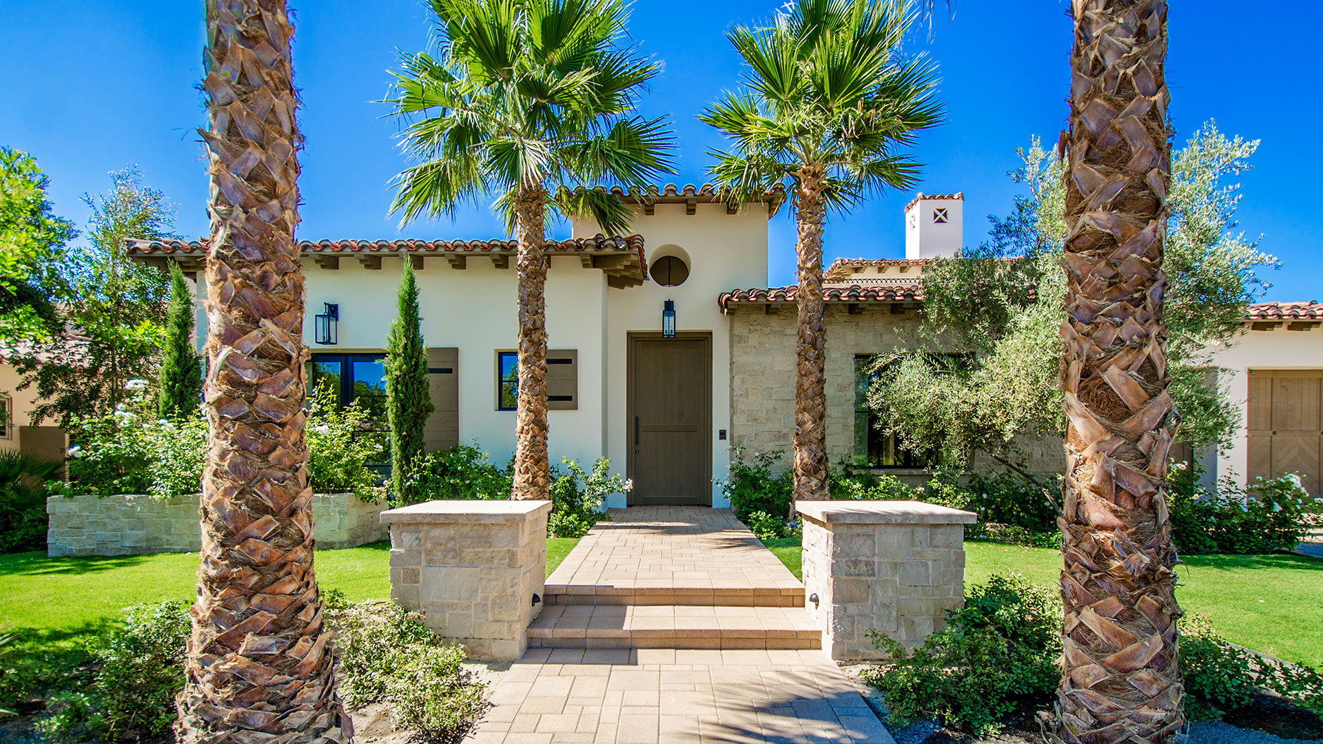 front of home with palm trees with regent buff traditional thin veneer installed on exterior
